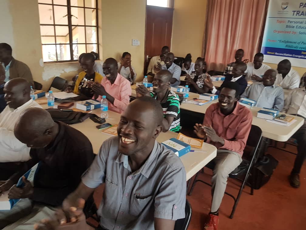 Pastors joyfully receiving the Bibles